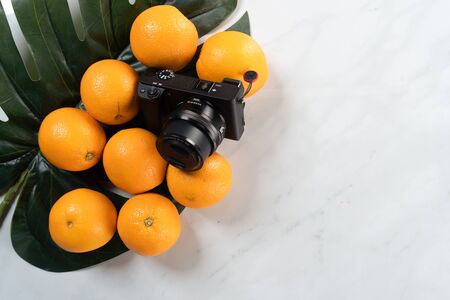 camera and oranges with marble backgroundの写真素材