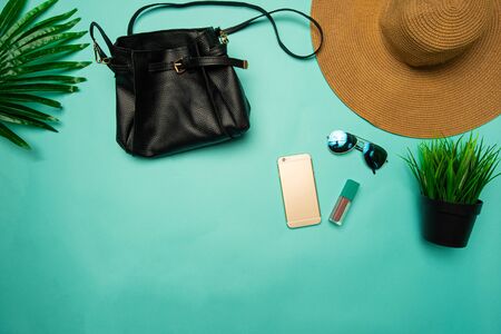 flat lay of brown beach hat and handbag on turquoise backgroundの写真素材