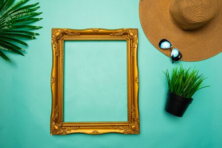 flat lay of brown beach hat and frame on turquoise backgroundの写真素材