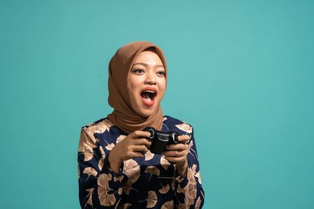 She was excited to play a game. At Turquoise color backgroundの写真素材
