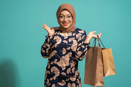 A woman who loves shopping at turquoise background.の写真素材
