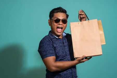 A guy who likes to shopping at turquoise background.の写真素材