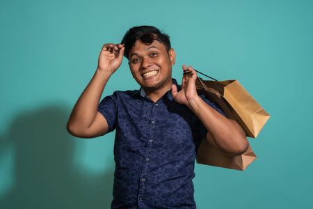 A guy who likes to shopping at turquoise background.の写真素材