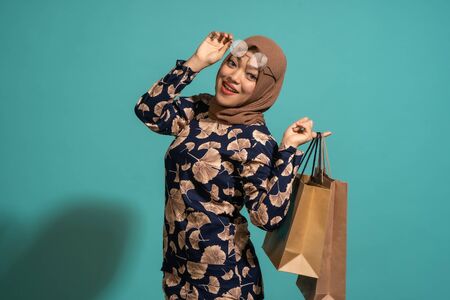 A woman who loves shopping at turquoise background.の写真素材