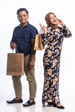 A man and woman who loves shopping at white backgrounds.の写真素材