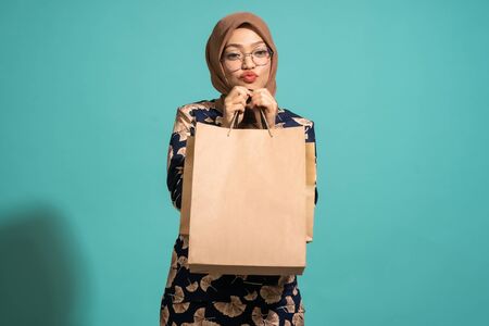 A woman who loves shopping at turquoise background.の写真素材
