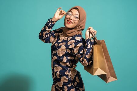 A woman who loves shopping at turquoise background.の写真素材