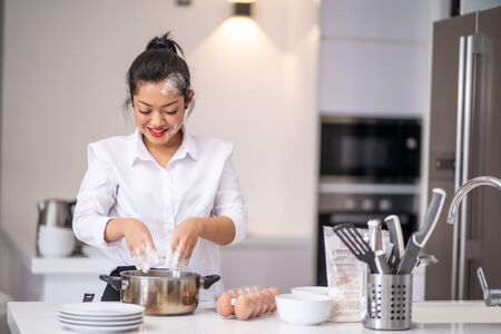 The woman was making flour in a bowl while smilingの写真素材