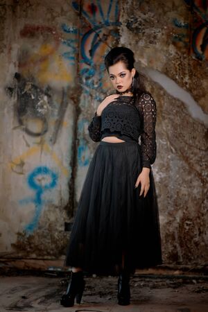 long portraits of beautiful women in black fantasy suits. standing in the background of a building.の写真素材