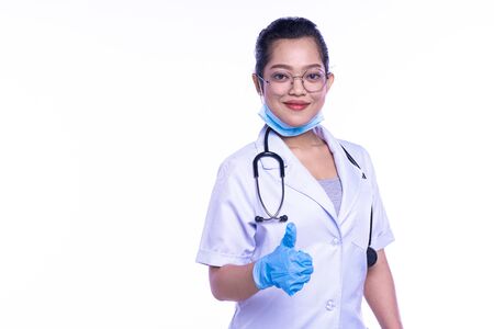 Happy woman doctor giving a thumbs up gesture to show that treatment of a patient has been successful and there is hope for a full recovery, On white backgroundの写真素材
