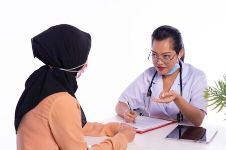 The doctor is describing the correct time to take the medicine to the patientの写真素材