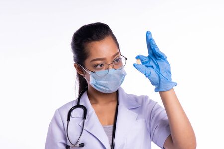 Doctors wear masks while looking at medicineの写真素材