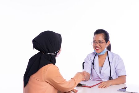 The smiling doctor gives the patient a handshakeの写真素材