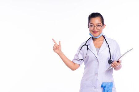 Smiling happy doctor pointing with finger on white backgroundの写真素材