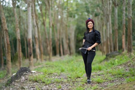 Female rubber tappers in the rubber tree row. Smiling look at the cameraの写真素材