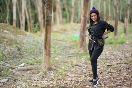 Female rubber tappers in the rubber tree row. Smiling look at the cameraの写真素材