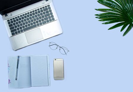 flat lay of laptop and notebook on light blue backgroundの写真素材