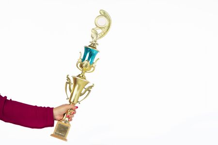 Teenage girls' hands are holding trophies, congratulations on success.Conception of victory in the competition.Focus on the trophyの写真素材