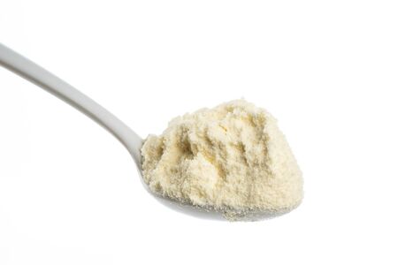 milk powder in a spoon close up shot isolate in white backgroundの写真素材
