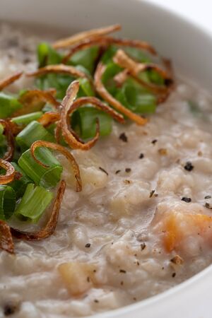 ramadhan famous food bubur lambuk in a white bowl and backgroundの写真素材