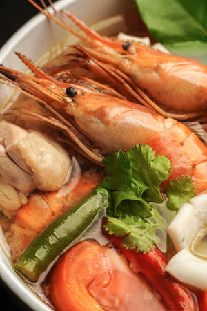 delicious tomyam seafood thai dish with freshwater prawn and black background close up shotの写真素材