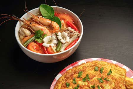delicious tomyam seafood thai dish with freshwater prawn and black backgroundの写真素材