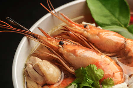 delicious tomyam seafood thai dish with freshwater prawn and black background close up shotの写真素材