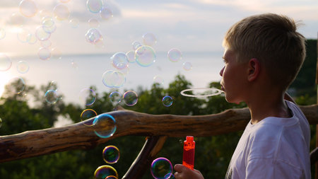 The boy is making soap bubbles. Closeup. Panoramic viewの写真素材