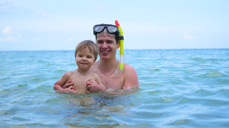 a guy with kid plays having fun in the sea.Snorkellingの写真素材