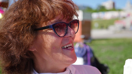 Woman is eating ice cream in the park. Food in the open airの写真素材