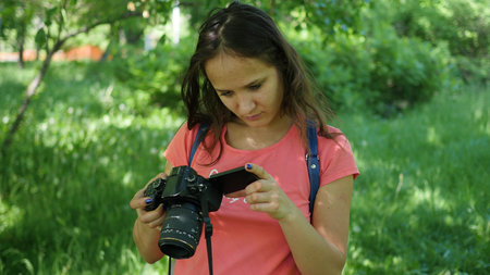 young girl holding a camera. To pose for the camera. Fun outdoors