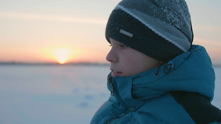 Guy walks in winter Park, sunset time. Healthy lifestyle, walking outdoorsの写真素材