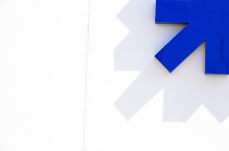 Abstract minimal concept with blue arrow on white wallの素材