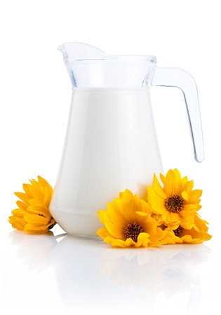 Jug of fresh milk and yellow flowers isolated on white backgroundの写真素材