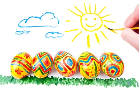 Child s picture by a water-colour  five easter eggs on a grass, a sun in sky with cloudsの写真素材
