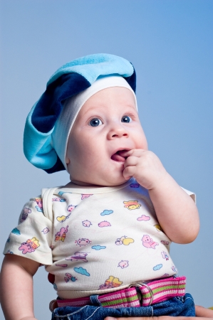 Amusing baby boy in a beret in a studio on a dark blue backgroundの写真素材