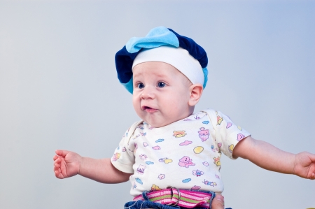 Amusing baby boy in a beret in a studio on a dark blue backgroundの写真素材