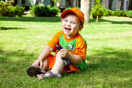 Little boy is in summer on a lawnの写真素材