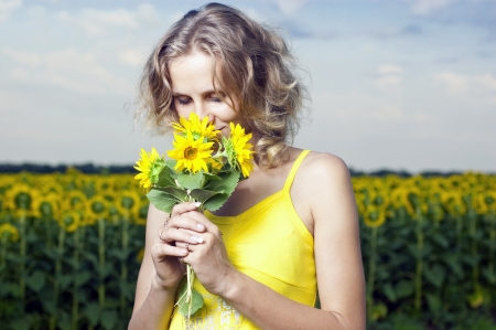 Sun young girl in the field with sunflowersの写真素材
