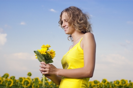 Sun young girl in the field with sunflowersの写真素材