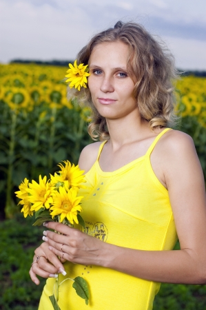 Sun young girl in the field with sunflowersの写真素材