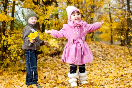 Little boy and girl play in a park in autumnの写真素材