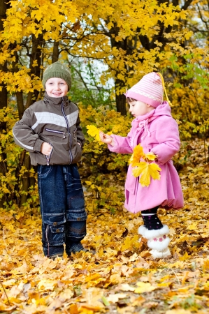 Little boy and girl play in a park in autumnの写真素材