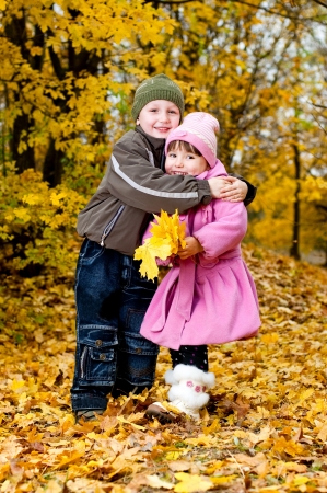 Little boy and girl play in a park in autumnの写真素材