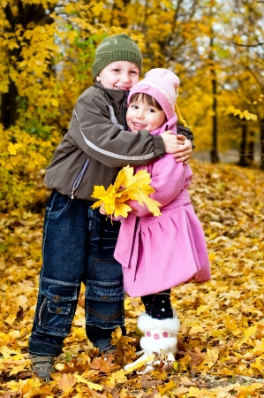 Little boy and girl play in a park in autumnの写真素材