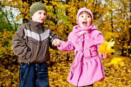Little boy and girl play in a park in autumnの写真素材