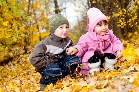 Little boy and girl play in a park in autumnの写真素材