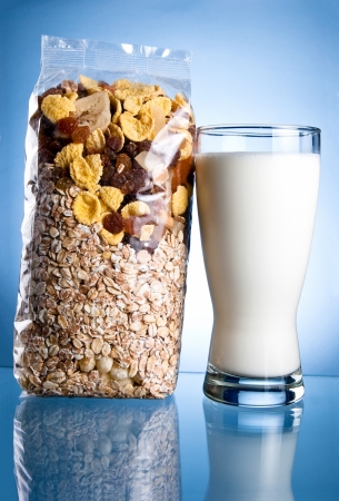 Fresh Glass of Milk and Closed Pack of muesli on a blue backgroundの写真素材
