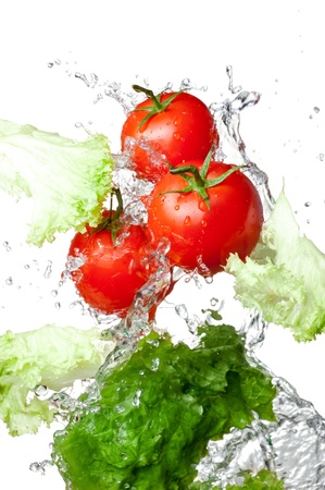 Three Fresh red Tomatoes and lettuce in splash water Isolated on white backgroundの写真素材