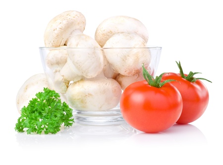 Fresh button mushrooms in Glass bowl, two tomatoes and parsley isolated on a white backgroundの写真素材